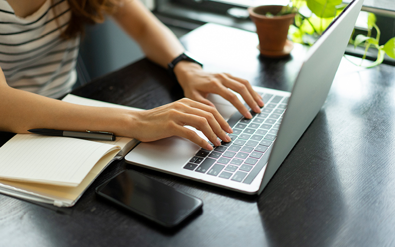 Woman's hands typing on laptop