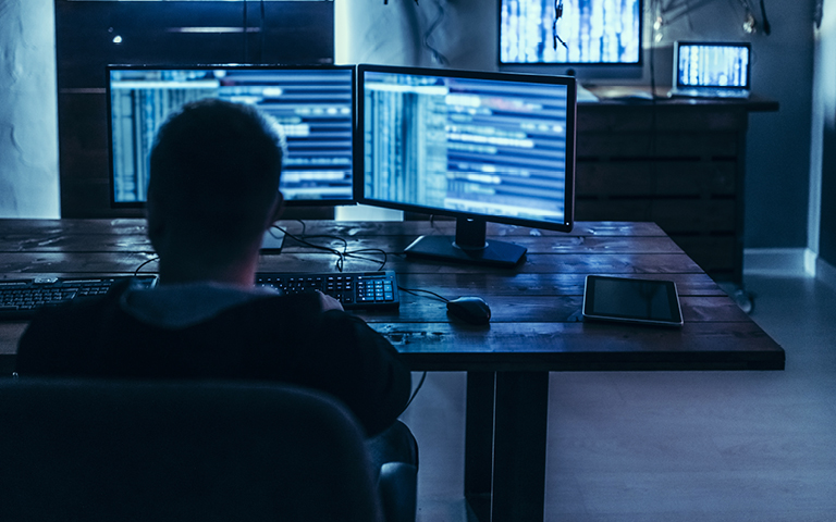 Healthcare worker sitting at desk in darkroom