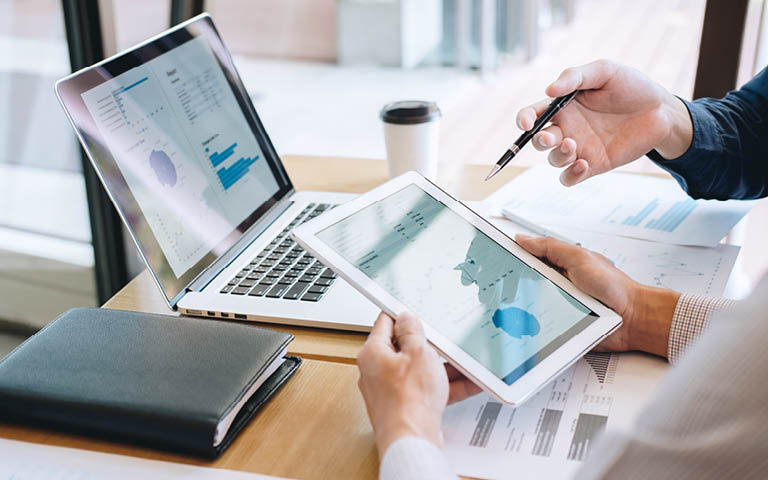 Photo: Dr discussing finances, using tablet