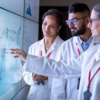 stock photo: grouo of reseracher look at HE stats (getty images)