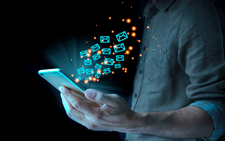 Photo illustration: man with phone and email icons coming from phone