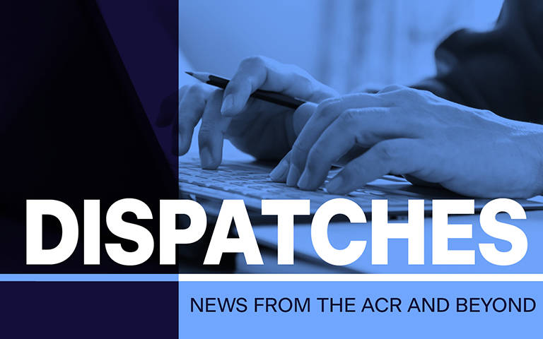 Blue tinted close up of hands typing at keyboard