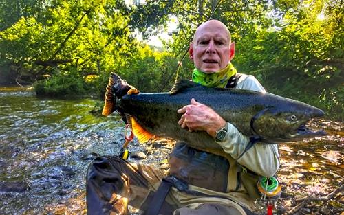 Bruce J. Hillman poses with female salmon on a fishing trip