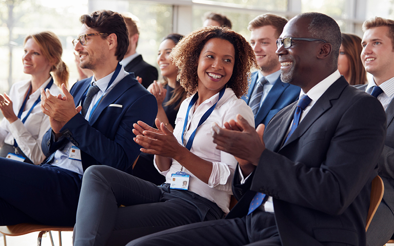 Photo: Smiling attendees at a business seminar