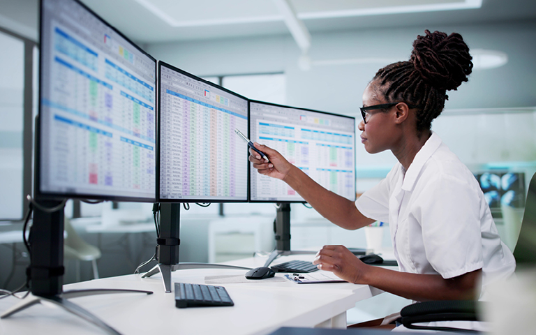 Person looking at computer screens entering medical codes