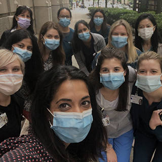 women wearing surgical masks poses for a selfie during a group walk
