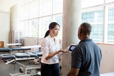 Doctor holding a tablet discussing with patient